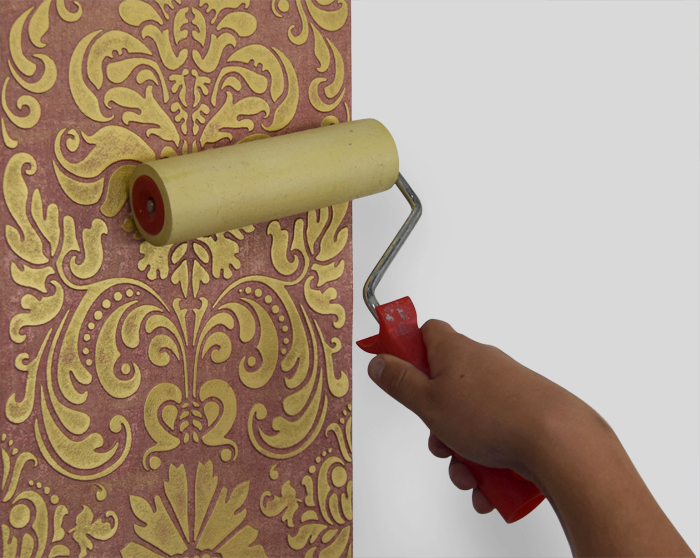 3. Carefully push any bubbles, wrinkles and adhesive excess out toward the borders with a paint-roller.